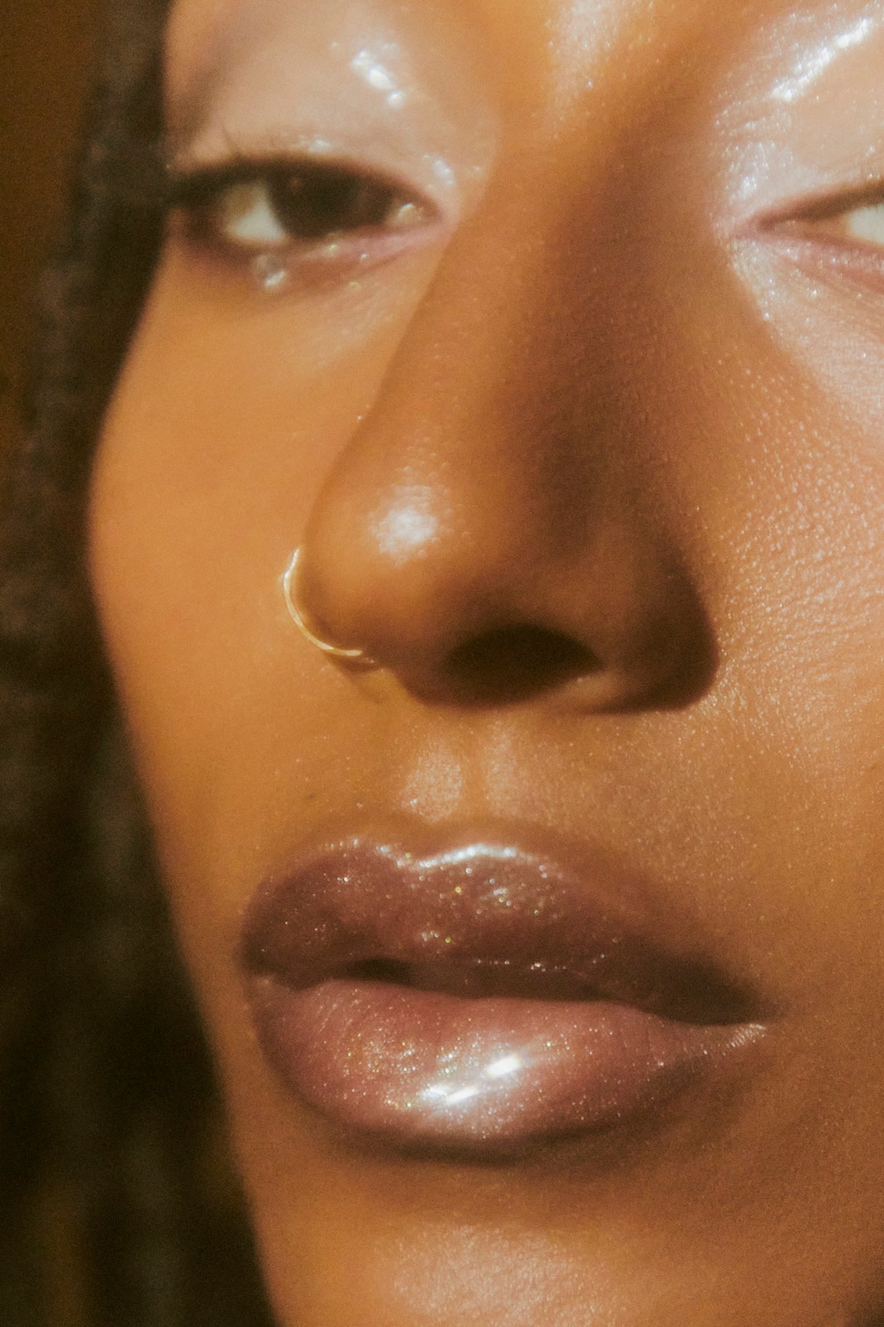 close-up of glossy glitter lips in warm golden light